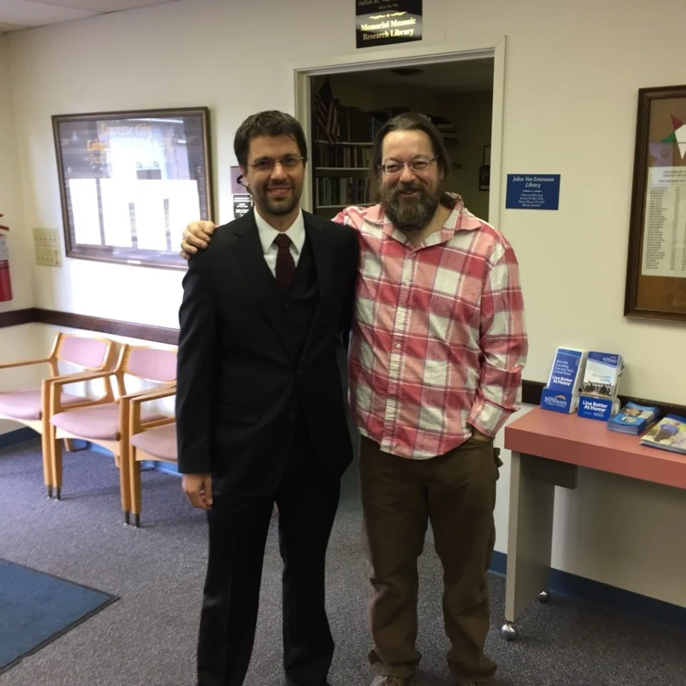 Two members standing together at a community gathering, displayed upright