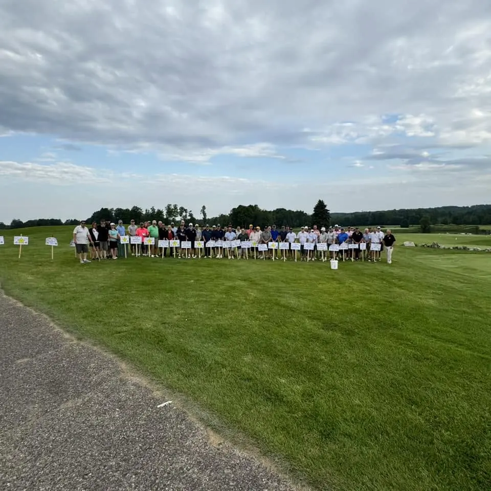 Golfers gathered outdoors during a Lodge golf outing