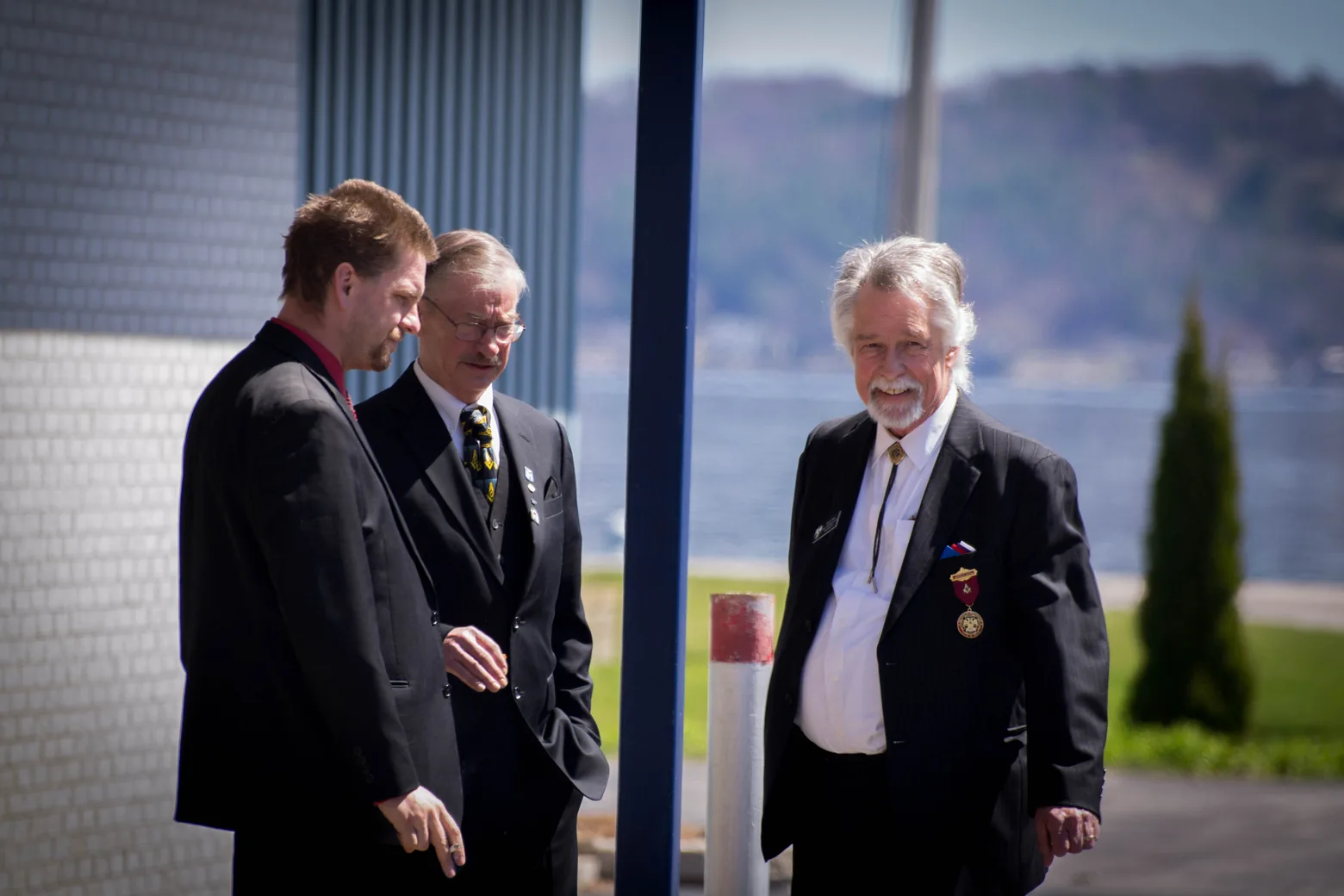 Three men in conversation outdoors
